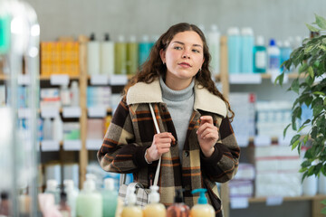Portrait of girl in winter clothes shopper choosing some products in a supermarket