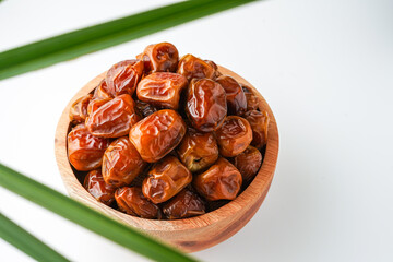 Dates fruit sukari or kurma sukari, in wooden bowl isolated on white background