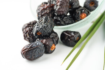 Dates fruit ajwa or kurma ajwa, in bowl isolated on white background