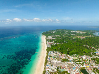 White sand beach with boats on clear water. Boracay, Philippines.