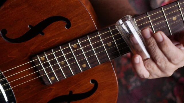 Male musician hand play Vintage Resonator acoustic dobro blues slide guitar.