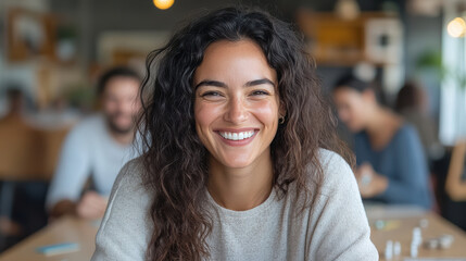 Smiling woman with curly hair in cozy setting, enjoying time with friends