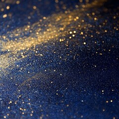 A dark blue surface speckled with gold glitter creating a sparkling and textured abstract background image