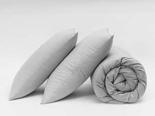 Two pillows and rolled up duvet on a white background