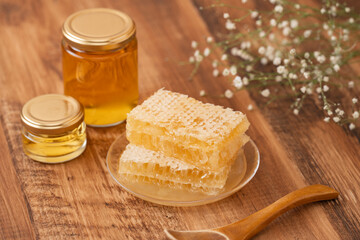 木目の背景に蜂蜜瓶とコムハニー