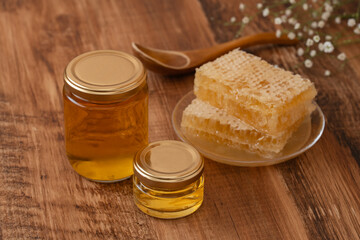 木目の背景に蜂蜜瓶とコムハニー