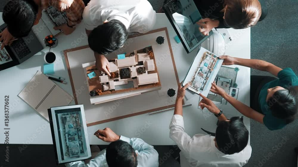 Poster top down view of manager pointing at house model and explain building design. aerial view of archite