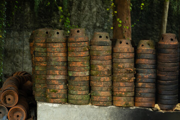 Pile of old terracotta plant pots covered with moss, with shallow depth of field