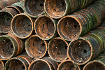 Pile of old terracotta plant pots covered with moss, with shallow depth of field