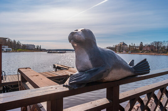 Sortavala, Russia - May 15, 2024: Cute wooden sculpture of a seal against the backdrop of the Vakkolahti Bay at the Sortavala-Center railway station.