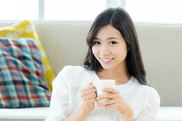 コーヒーカップを持つ若い女性
