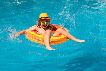 Child in pool in summer day. Children playing in swimming pool. Kids holidays and vacation concept.