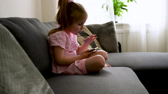 Girl using her smartphone, watching video online at home