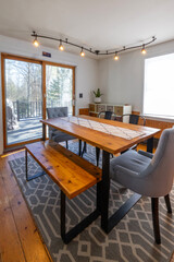 Dining room with overhead lighting, reclaimed wood table and bench