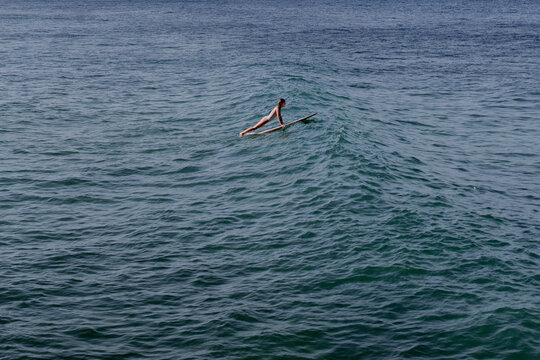 Happy wet woman surfing in the ocean
