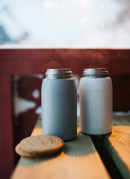 hot chocolates in flasks on a bench with biscuits outdoor snacks