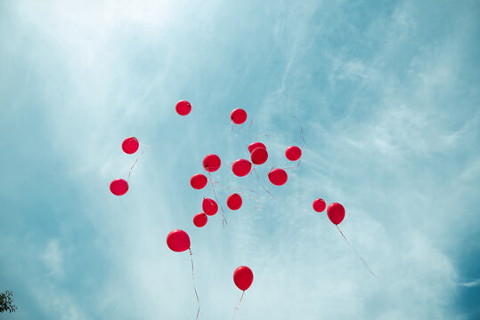 A lot of red balloons in sky