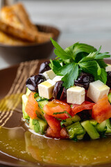 Shepherds salad served in a porcelain plate with crispy bread on the side. Turkish name: Coban Salata