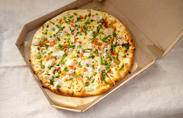 Delicious pizza with mozzarella, chicken, pepper, corn and green peas and carrots