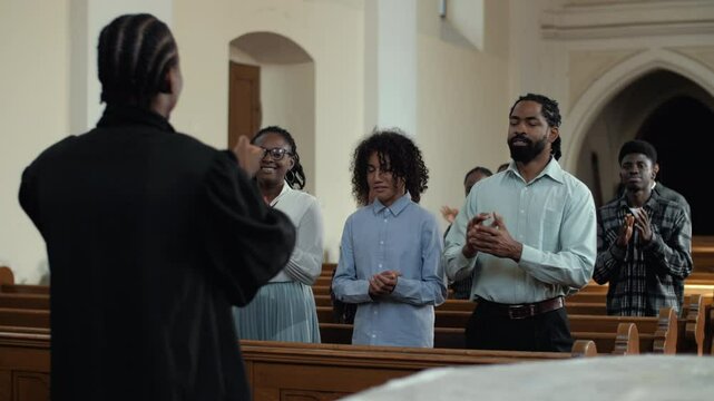 Pastor leading congregation in clapping and singing during church service