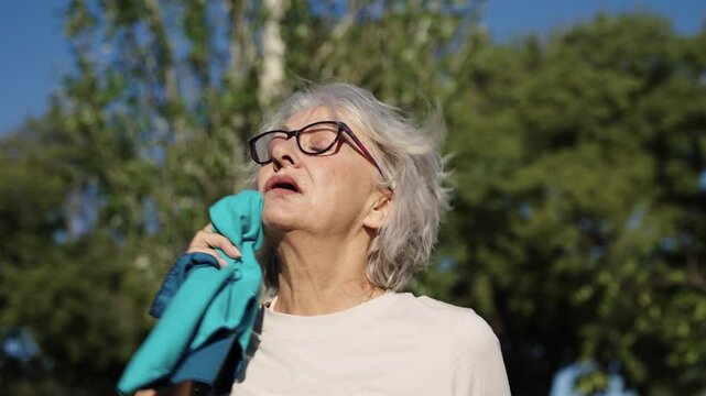 Senior woman wiping sweat from face in slow motion