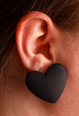 A woman with black earrings that are shaped like hearts
