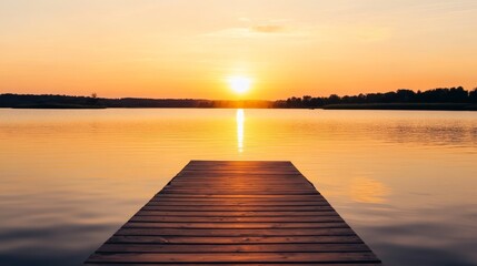 Obraz premium Serene sunset over a calm lake with a wooden dock leading to tranquil waters, evoking peace