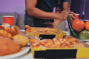 Happy young friends group having lunch at home. Asia family party eating pizza food and laughing enjoying meal while sitting at dining table together at house. Celebration holiday and togetherness.