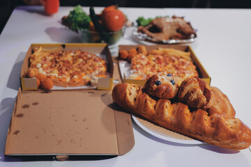 Happy young friends group having lunch at home. Asia family party eating pizza food and laughing enjoying meal while sitting at dining table together at house. Celebration holiday and togetherness.