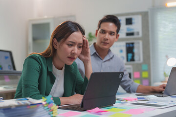 Stressed businesswoman having problems at work with her male colleague looking at her