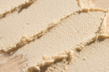 Cosmetic texture of scrub, exfoliating body product top view on beige background, macro.