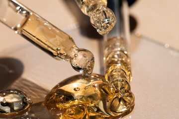Several cosmetic pipettes on a beige background with essential oil, macro.