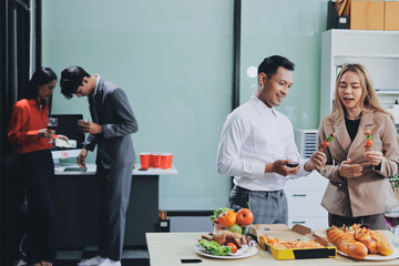 Asian office colleagues and friends enjoy a daytime BBQ with pizza and beer, celebrating Halloween and cheering for their favorite soccer team, creating a lively atmosphere filled with joy.