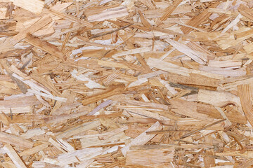 Wood chip texture background with rough, organic pattern of shredded wooden fragments in various...