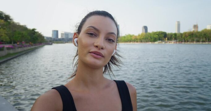 Cheerful woman capturing city lake backdrop, vlogger excitedly sharing travel moments, vlogger showcasing genuine experiences, ideal for upbeat social media or tourism ads worldwide.