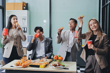 Asian office colleagues and friends enjoy a daytime BBQ with pizza and beer, celebrating Halloween and cheering for their favorite soccer team, creating a lively atmosphere filled with joy.