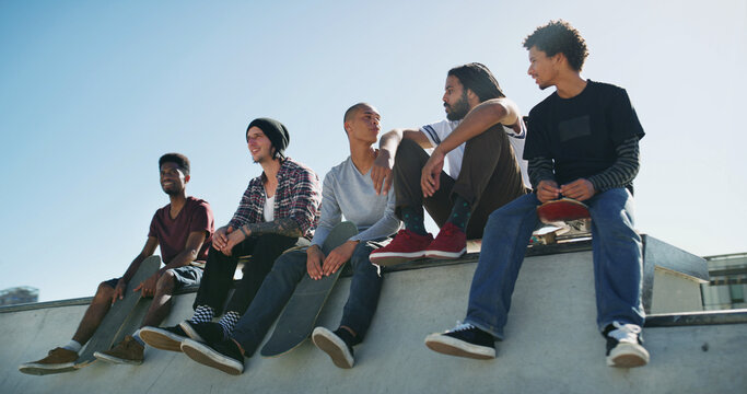 Skateboard, group and friends outdoor on ramp for relax, bonding or sports break. Skate park, talking and men together for holiday, resting or hangout for conversation with cool fashion or streetwear