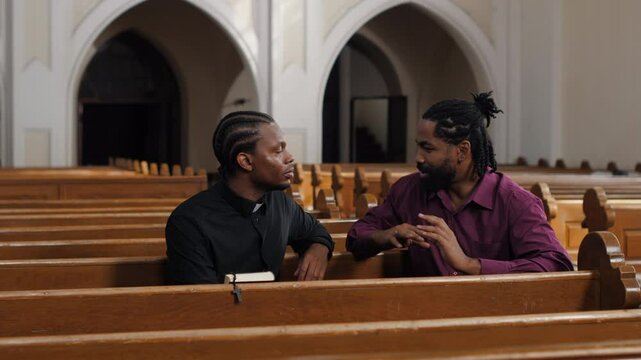 Priest listening to a man's confession in church