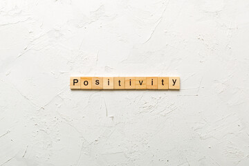 positivity word written on wood block. positivity text on cement table for your desing, concept