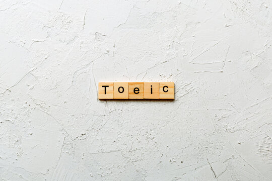 toeic word written on wood block. toeic text on table, concept