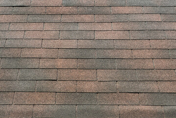 Roof shingles or slate tile material in warm brown and grey color. Clay or slate tiles roofing is a common view for architectural roof finishes mainly in tropical countries.