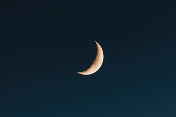 Crescent moon shining in the dark blue night sky