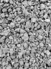 Crushed metallurgical slag. Fine fraction. Porous structure. Production waste. Recycling, reuse. Use for road construction. Gray background. Black and white photo. Copy space for text.
