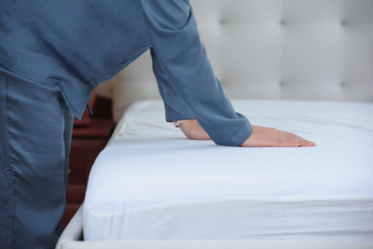 Woman's hand puts a cover on the mattress to protect it from water and house dust mites