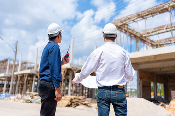 Specializing in village design, two male Asian engineers contribute to the construction industry by...
