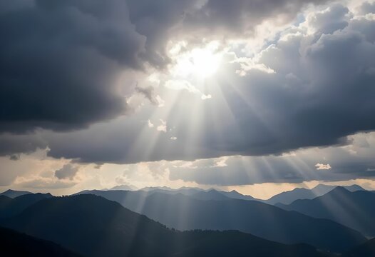 sun rays piercing through dark clouds over mountain range
