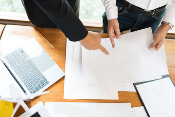 Within the Architects Group office, architects meticulously craft blueprints and designs that shape...