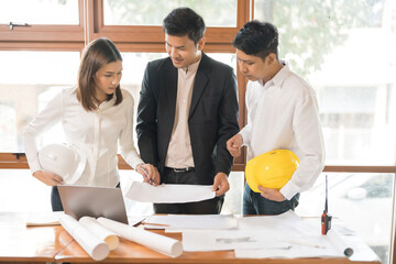 Architects Group members collaborate in their office, drafting blueprints and refining designs to...