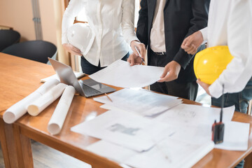 The collaboration of architects and their meetings in the office with blueprints and laptops, beautifully designed structures for the future of industrial and rental housing businesses.