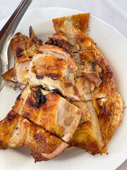 Close up texture of food dish, Thai style whole arilled chicken served on white plate